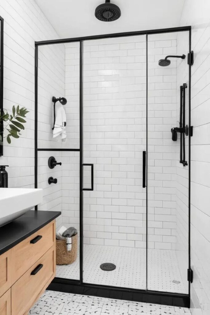A black-framed shower door adding an industrial touch to a black and white bathroom.