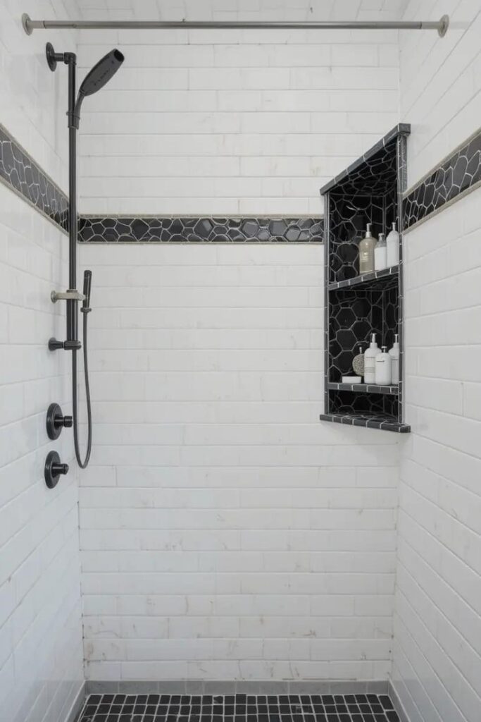 A black shower niche inside a white tiled shower for a bold contrast.
