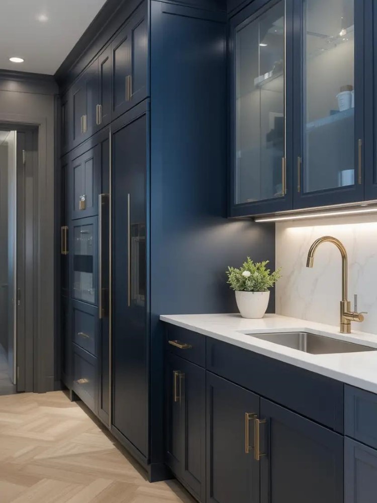 A kitchen featuring navy blue cabinets with gold hardware and white marble countertops for a sophisticated look.