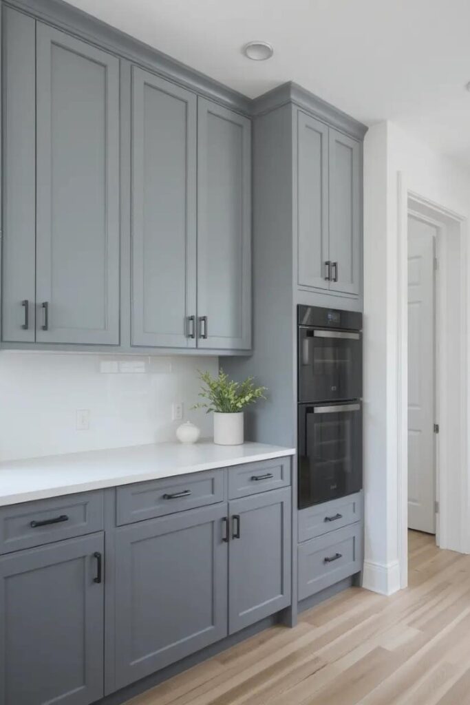 Modern kitchen with light gray upper cabinets and dark gray lower cabinets, matte black hardware, and a clean, minimalist design that creates contrast and balance.