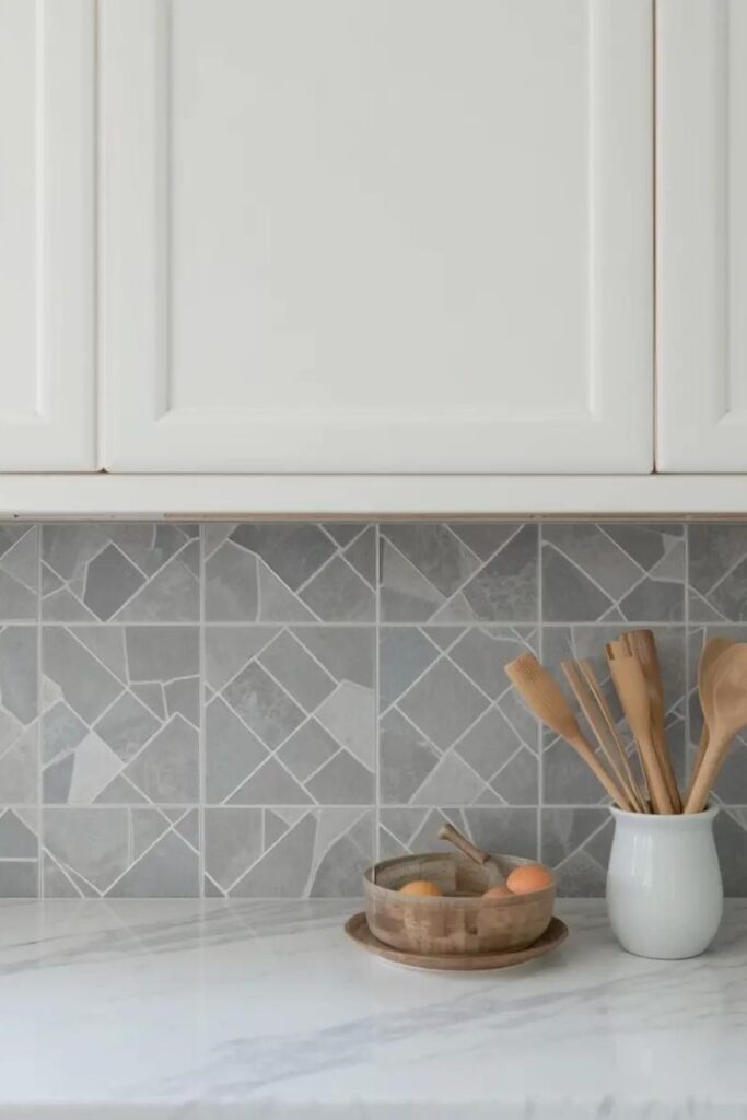Light gray herringbone subway tile backsplash in a transitional kitchen.