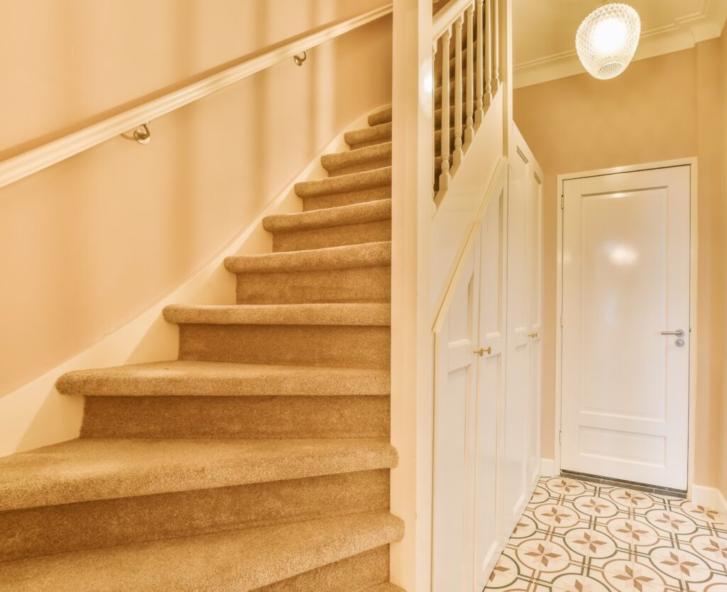 a staircase with carpeted stairs and a white door