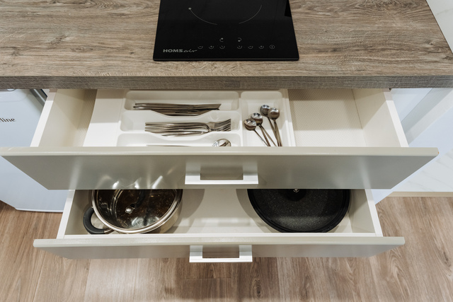 A kitchen drawer that is filled with various utensils