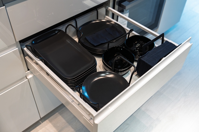 Organized Kitchen Drawer with Stylish Black Dinnerware and Napkins for Elegant Dining
