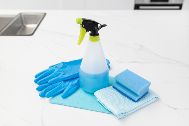 Cleaning supplies on modern kitchen. House cleaning concept. Copy space