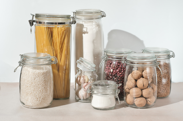 eco friendly kitchen storage. keeping food fresh, glass jars full of grains , pasta and flour. transparent containers for pantry.