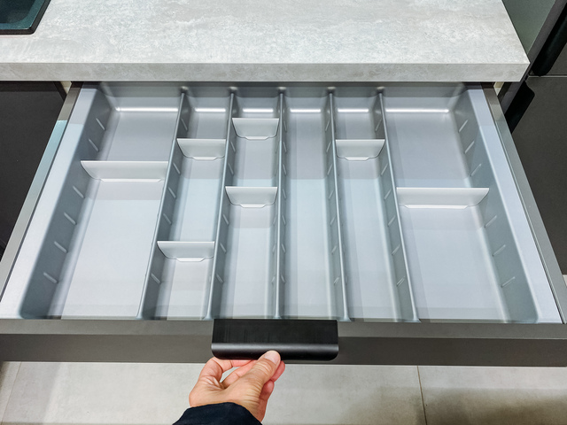 Empty gray kitchen drawer organizer showing clean compartments, with minimalist organization setup.