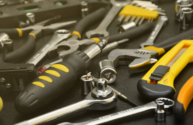 Handyman tool kit on black wooden table. Many wrenches and screwdrivers, pilers and other tools for any types of repair or construction works. Repairman tools
