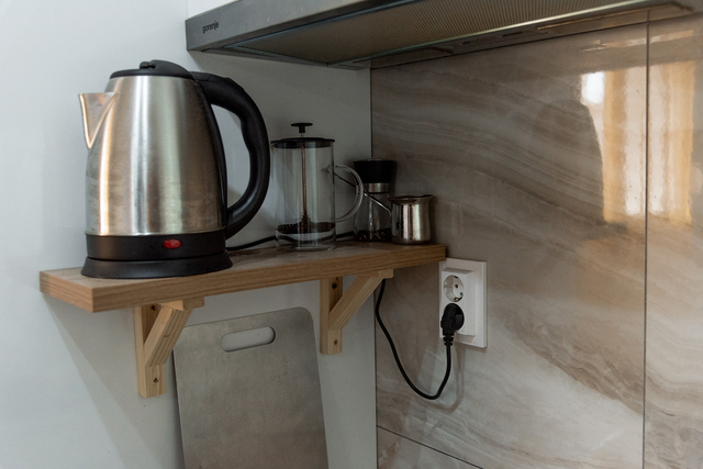 Kettle, teapot and spices on shelf, the organization of space in the kitchen interior