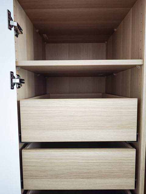 Modern wooden cabinet interior features empty drawers and shelves, highlighting a minimalist approach to design and organization for storage solutions