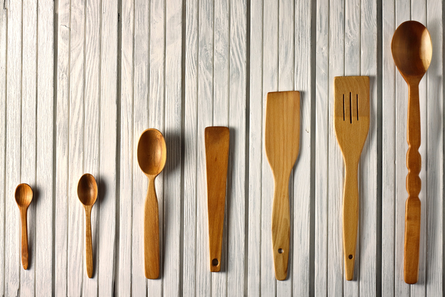 Old wooden spoons and stirrers on white background.