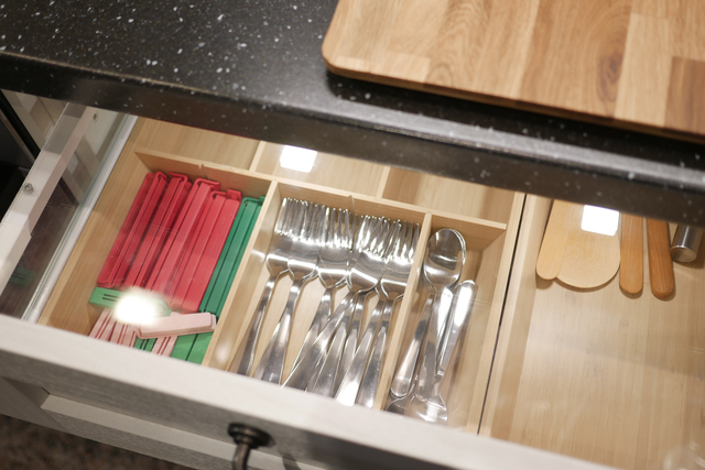 Organize kitchen drawer for efficient storage of cutlery and utensils, creating a modern interior