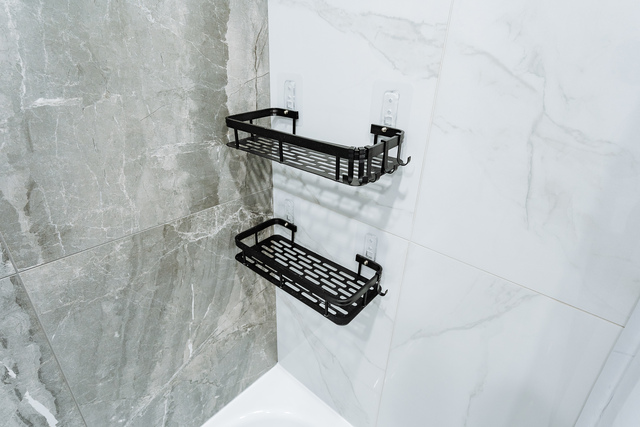 stylish bathroom display, minimalist bath accessories organized for professional product photography, retail stylist meticulously arranging bath essentials on marble surface for promotional images