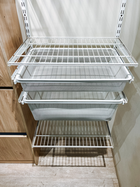 This beautifully designed family home features a spacious closet with shelves for organization and practical wall baskets for effective storage, ensuring easy access to essentials