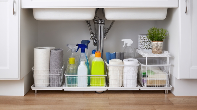 Under-Sink Storage Organization With Cleaning Supplies And Towels. Efficient Use Of Space For Household Cleaning Essentials.